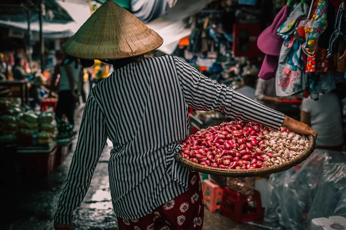 Une vendeuse avec un panier au marché Dong Ba